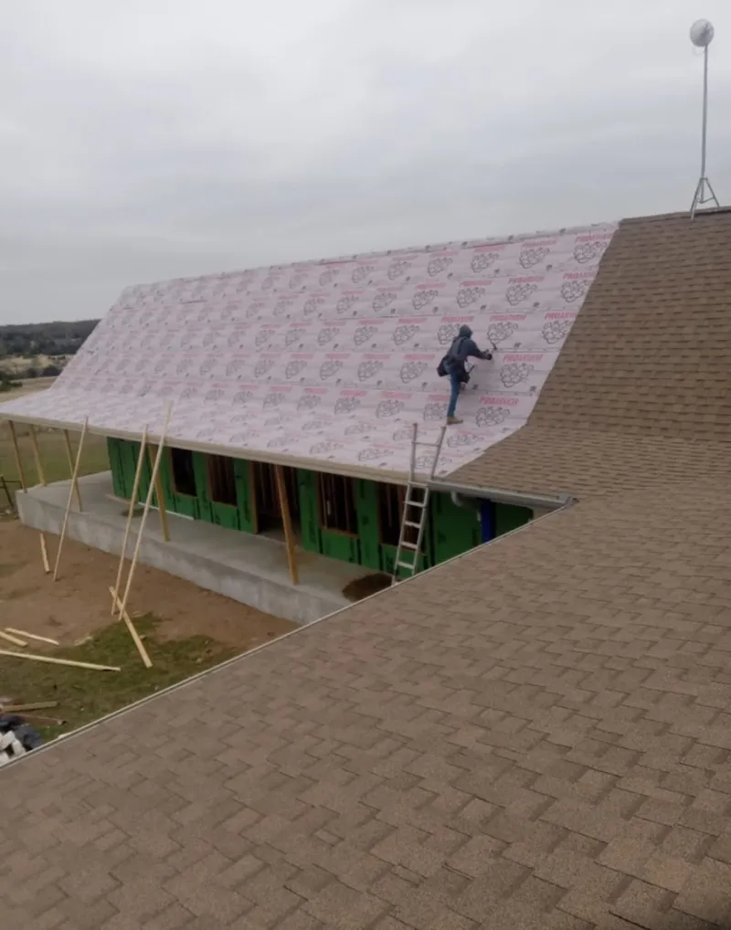 Worker preparing underlayment for a metal roof installation in Georgetown